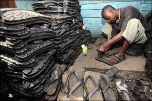 Житель столиці Кенії Найробі робить та продає на міському ринку капці зі старих автомобільних шин.  Чоловік заробляє більше долара щодня і вважає себе хорошим підприємцем