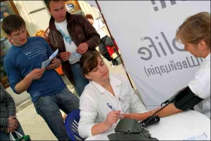 Медработник Наталия Онищук измеряет артериальное давление в палатке на проспекте Шевченко