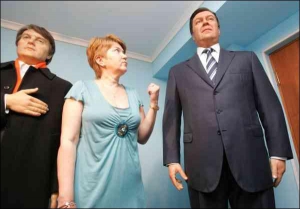 Заступник директора музею воскових фігур Тетяна Суханова між копіями президента Віктора Ющенка та прем’єр-міністра Віктора Януковича