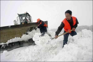 Працівники дорожньої служби розчищають швидкісну трасу 303 у китайському місті Хамі Сінцзянь-Уйгурського округу. Негоду принесло із Сибіру.  Сніговий покрив сягає півметра, температура повітря з 25 градусів тепла опустилася до нуля