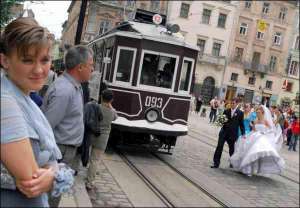 Молодята Назар і Марта Балабани прямують до старовинного трамвая на площі Ринок, щоб сфотографуватися на згадку про день весілля
