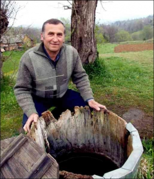 Дмитрий Палийчук из-под Космача на Франковщине берет воду из колодца, который он всегда чистит до восхода солнца на Юрия