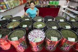 Владелица чайного магазина в Шанхае ждет посетителей. В Китае чай выращивают в 18 провинциях и автономных районах. Из свежих листков одного куста китайцы могут приготовить свыше 500 сортов, по-разному обрабатывая один чайный лист