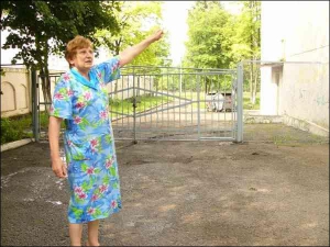 Жителька Тернополя Марія Біловус показує ворота, через які перелізла, наздоганяючи злодія