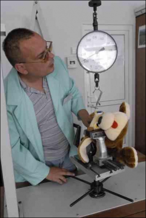 Працівник київського інституту ”Укрметртестстандарт” Сергій Каспаров перевіряє у лабораторії, наскільки добре тримаються очі у іграшкової плюшевої собаки