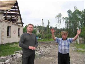 Свідки стихії Анатолій Добринін (ліворуч) і Сергій Проць стоять біля зруйнованої хати, над якою пролетіло торнадо з вогняною кулею. У хаті вивалило шмат стіни та зірвало з даху шифер