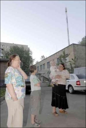 Жительница дома №24 Виктория Катрич (на фото слева), ее внук и соседка говорят, что у них из-за антенны ”Киевстар” во дворе ухудшается здоровье
