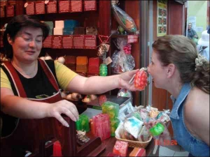 Продавец магазина ”Лавка мыльных сокровищ”, что в ”Фуршете” на Старовокзальной, предлагает понюхать клубничное мыло киевлянке Неле Лашковой