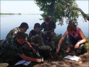 Ученики Малой милицейской академии во время похода в лес на берегу Днепра варят пшенную кашу