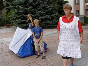 Мати шістьох дітей, рівнянка Катерина Веніславська та її молодший син Юрко біля Рівненської міськради. У жінки покалічена права рука