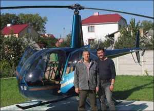 Ровенский бизнесмен Юрий Романенко (слева) на площадке у своего дома готовится подняться в небо вместе со своим инструктором Дмитрием Бородаем