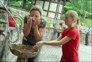 Марина Талько із донькою Тонею з Одеської області вмиваються водою із джерела ”Юзя” у парку біля центрального бювету мінеральних вод у Трускавці. Джерельна вода багата сріблом і гліцерином, тому пити її заборонено