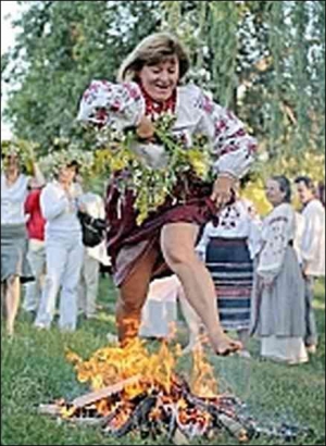 Родноверка прыгает через купальский огонь на праздновании языческого бога Купайла 21 июня в столичном Гидропарке