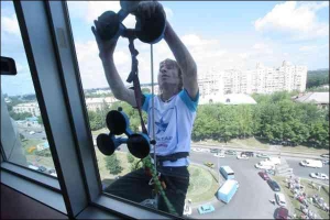 Алан Робер піднімається по 16-поверхівці за допомогою присосок. На півдорозі від однієї відлетів шматок пластмаси