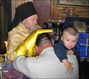 Отець Веніамін із села Ільківка під Вінницею благословляє батька й сина, які приїхали до нього з-поза меж Вінницької області