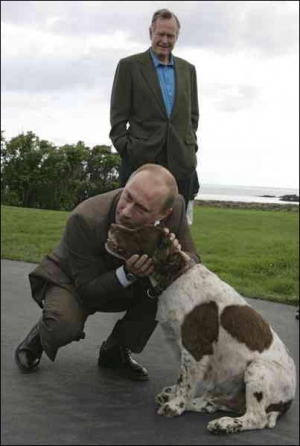 Прибыв в поместье американского президента Джорджа Буша, российский руководитель Владимир Путин поздоровался с его собакой. На заднем плане стоит Джордж Буш-старший