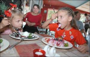 Сестер Лизу (слево) и Настю Карпович в столичный ресторан ”Бегемот” привели бабушка с дедушкой, которые живут в Фастове и на несколько дней приехали к внукам в Киев. Девочки заказали черничный пирог и фруктовый мусс, съели по половине каждого десерта