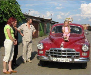 Микола Поляруш показує свій ЗІМ Людмилі, сестра якої незабаром одружиться. Її дочка Танюша попросилася посидіти на капоті машини