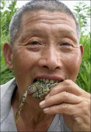 Китаец Янг Мушенг ест живую лягушку. Так он двадцать лет подряд лечит кашель