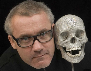 Скульптор Демиен Хирст и его работа ”Ради Божьей любви” — человеческий череп, сделанный из платины в натуральную величину. Он украшен 8601 бриллиантом