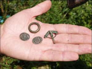 На долоні краєзнавця Миколи Йолтуховича знайдені в Барській фортеці польські мідяки-”баратинки” та застібка для одягу у формі маленького арбалета