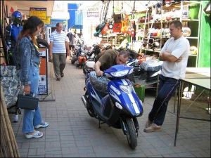 Николай Кущ (справа) из Винницы торгует новыми мотороллерами на Центральном базаре Винницы. Показывает скутера с двигателем 50 кубов за 3 тысячи гривен. Мужчина говорит, покупать более мощный моторолер невыгодно. На них нужно оформлять много бумаг.