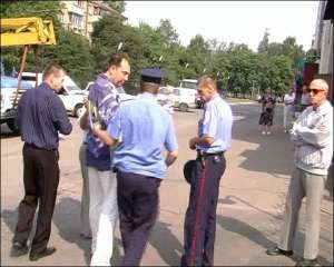Милиционеры столичного Соломенского райотдела ведут задержанного 5 июля председателя правления СПК ”Меридиан” Константина Архангельского (второй слева) в служебную машину