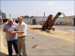 Директор опытной станции Борис Федчук (справа) с заведующим складом Борисом Усиком проверяют, просохла ли пшеница