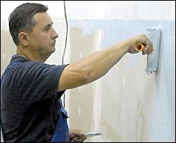 В’ячеслав Литвиненко обробляє грунтовкою стіну з гіпсокартонних плит