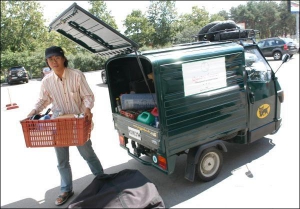 В кузове маленького грузовика Арима Рютаро держит палатку, велосипед, несколько кастрюль и газовую плитку