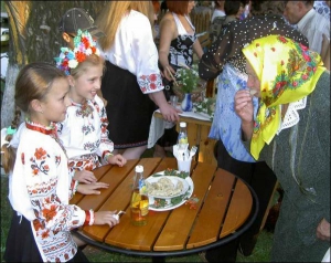 8-летняя Дина и ее сестра Настя, 7 лет, угощают варениками одного из членов жюри Анастасию Уманец из села Малая Севастьяновка