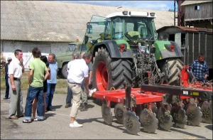 У Галайківцях Мурованокуриловецького району італійські агрономи біля новенького трактора ”Фент”, який коштує 170 тисяч євро. Це перше з 11 сіл, де вони почали працювати на орендованій землі