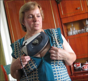 Надія Павлик з міста Калуш Івано-Франківської області тримає на собі радянську праску вагою 3,2 кілограма