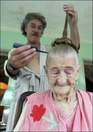 Кубинець Еліо Ґарсія робить зачіску своїй хрещеній матері 107-річній Мері МакКарті з Канади. Жінка 62 роки живе на Кубі. Через напружені відносини між країною і США вона не може отримати свої гроші з американського банку