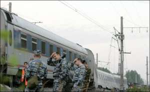 Міліція охороняє місце аварії потягу поблизу села Малая Вішера, за 500 км від Москви. Після вибуху саморобної бомби він зійшов з рейок