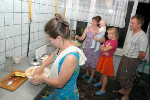 Жители общежития ”Киевгорстроя” на улице 50-летия Октября готовят ужин. На этаже на 37 семей туалет, три кухни, комната с умывальниками и прачечная. На всех жителей общежития одна душевая. За комнату площадью 18 квадратов семья платят 450 гривен в месяц