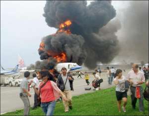 Пассажиры убегают от самолета, который начал дымиться сразу после посадки в аэропорту японского города Наха и взорвался, когда все покинули его борт