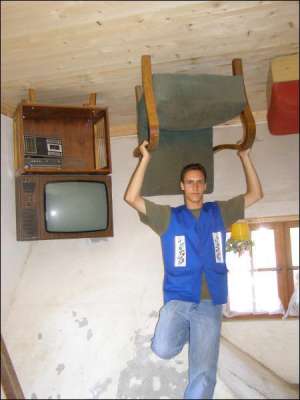 Экскурсовод в доме вверх  ногами Яцек Желинский показывает свисающую с пола мебель