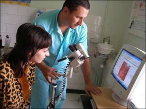 Игорь Филипюк показывает пациентке, как работает кольпоскоп — аппарат для осмотра шейки матки