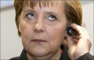 Канцлер Німеччини Ангела Меркель говорить по мобільному через найменшу блютуз-гарнітуру ”Моторола H5 Мініблу” на виставці з інформаційних технологій та комунікації в німецькому місті Ганновер