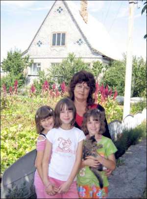 Раїса Чикаленко з дівчатками, яких узяла на виховання з інтернату. Анжела тримає кота Масіка, поруч — її сестра-двійнючка Леся, ліворуч — Аня