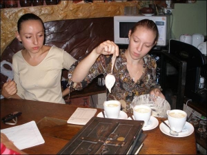 Варвара Смоліна (ліворуч) та її напарниця Людмила Тищенко з львівської кав’ярні ”Золотий дукат” показують, як приготувати каву ”Поцілунок привида” — у чашку з напоєм додають солодку пінку