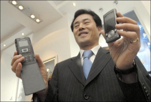 Голова українського представництва компанії ”Самсунґ Електронікс” Джен Чан Йон під час відкриття першого фірмового салону  показує два нові телефони, які з’являться у столичних магазинах у жовтні