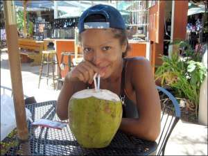 Гайтана пьет сок кокоса на острове Мауи, на Гавайях