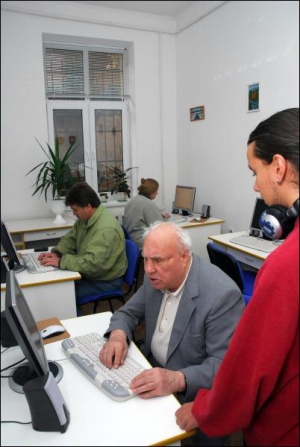 Петро Кондашов, викладач комп’ютерного центру при бібліотеці для людей із вадами зору у Львові, допомагає відвідувачу Олексієві Ракузі, 82 роки, прослуховувати аудіофайли