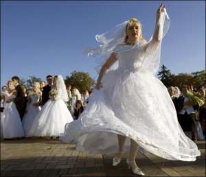 Невесты танцуют во время массовой регистрации брака на Михайловской площади в Киеве. В субботу с бракосочетанием здесь поздравили 70 пар молодых