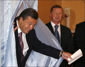 Виктор Янукович, проголосовав, выходит из кабинки. Минутой раньше здесь стояла его жена Людмила. Но фотографы попросили ее не мешать. Она поникла и отошла в сторону. Поэтому ее мужа сфотографировали без нее