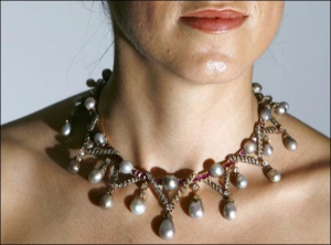 Працівниця аукціону ”Крістіз” демонструє намисто з перлів, яке належало французькій королеві Марії Антуанетті. Вона була відома своєю непомірною тягою до розкошів 