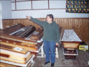 Работница дома панихид на ужгородском кладбище ”Кальвария” Руслана Комар показывает гробы, которые можно заказать в комбинате коммунальных услуг