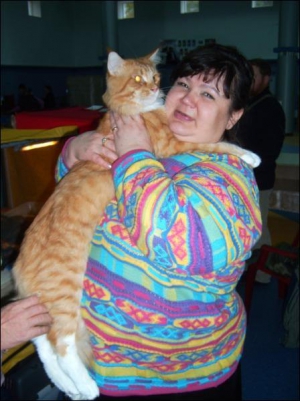 Татьяна Емельянова из Запорожья держит кота Малыша Дзензибара породы мейн-кун. Животному полтора года, весит оно восемь килограммов. Хозяева купили кота в прошлом году за 1,2 тысячи долларов. Фото сделано на выставке в Полтаве